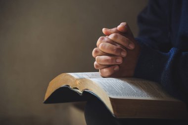 Eller inanç için kilise kavramı bir Kutsal Kitap üzerinde dua katlanmış