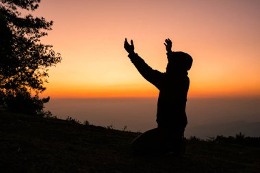Silhouette of christian man hand praying