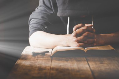 Religious young man praying to God in the morning