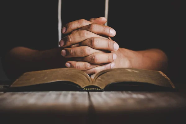 Enfoque suave en una mano del hombre mientras reza por la religión cristiana — Foto de Stock