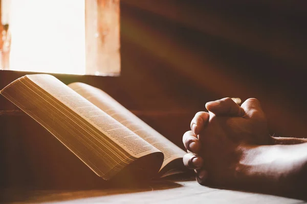 Soft focus on a hand of man while praying for christian religion — Stok fotoğraf