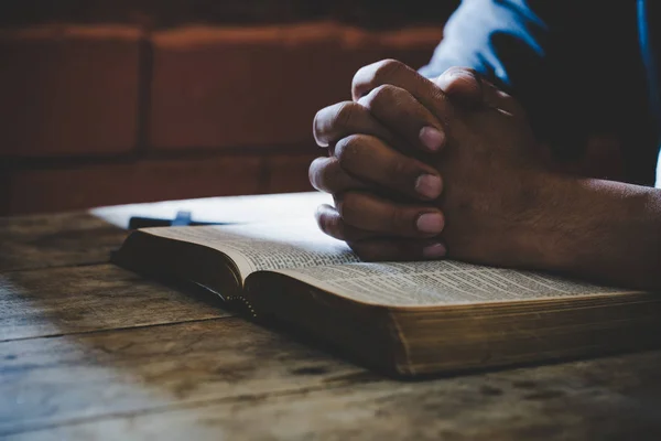 Enfoque suave en una mano del hombre mientras reza por la religión cristiana — Foto de Stock