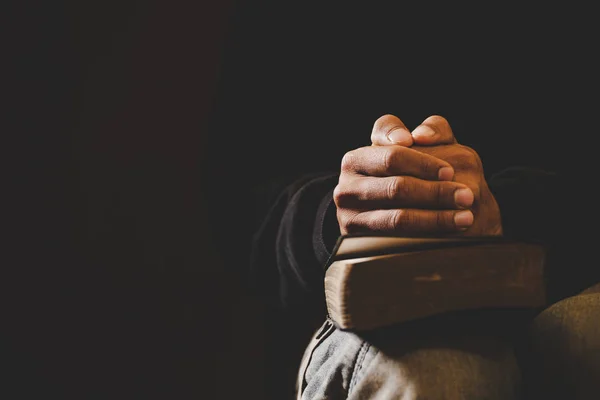 Soft focus on a hand of man while praying for christian religion — Stock Photo, Image