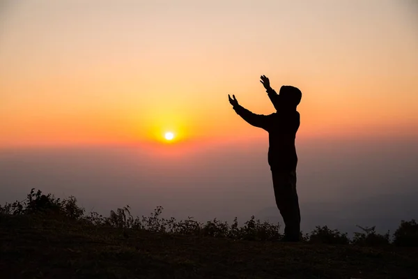 Silhouette of man praying in the sunrise — Stock Photo, Image