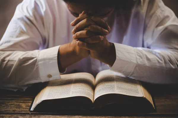 Mani giunte in preghiera su una Sacra Bibbia nel concetto di chiesa per fare — Foto Stock
