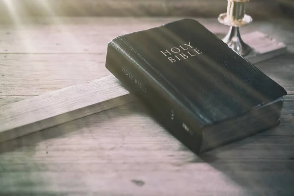 Bíblia sobre mesa de madeira de carvalho velho com luz de janela — Fotografia de Stock