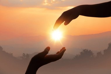 Gün batımının arka planında yardım eli uzatıyorlar.. 