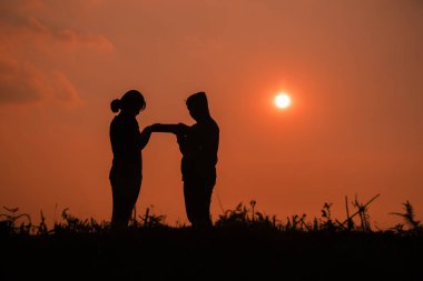 İncil 'le Tanrı' ya dua eden iki genç kızın silueti. Daha iyi bir hayat dilemek için Tanrı 'ya dua et. Hristiyan hayatı kriz duası..