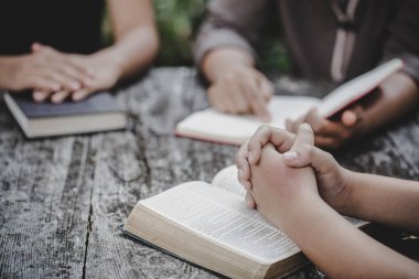 Farklı kadınlardan oluşan bir grup birlikte dua ediyor, Hıristiyanlar ve İncil okuyor.. 