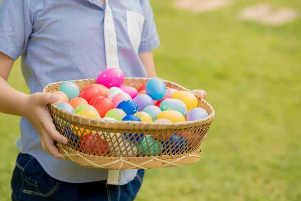 Primer Plano Niño Sosteniendo Cesta Llena Coloridos Huevos Pascua Pie — Foto de Stock