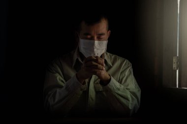 PM2.5 ve Covid-19 'u korumak için maske takan adam. Sabah Corona virüsüne yeni bir gün özgürlüğü için dua ediyor. Asyalı erkekler Tanrı 'ya şükür için el ele dua ediyorlar. Boşluğu kopyala.