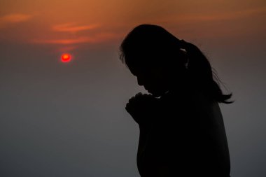 Güzel gündoğumu arka planı için sabah dua eden bir kadın silueti.