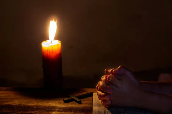 在一个黑暗的教堂里 在一个用宗教蜡烛 宗教和信仰观念进行祈祷仪式的过程中 妇女们手拉着一本古老的神圣圣经 — 图库照片