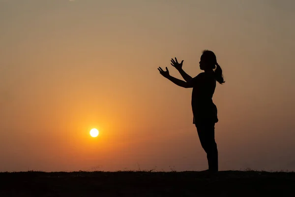 山の上で腕を上げて立ち 美しい日の出の背景で祈る女性のシルエット — ストック写真