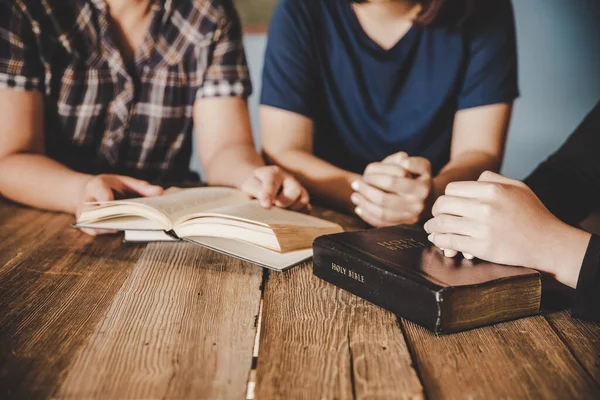 Hıristiyan ailesi evde Tanrı 'ya tapıyor, kutsal kitap ahşap masa üzerinde inanç, maneviyat, ibadet ve din kavramı..