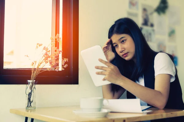 Stressed business woman working on wooden table in coffee shop