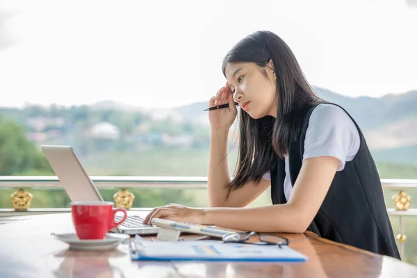 Stressed business woman working on wooden table in coffee shop