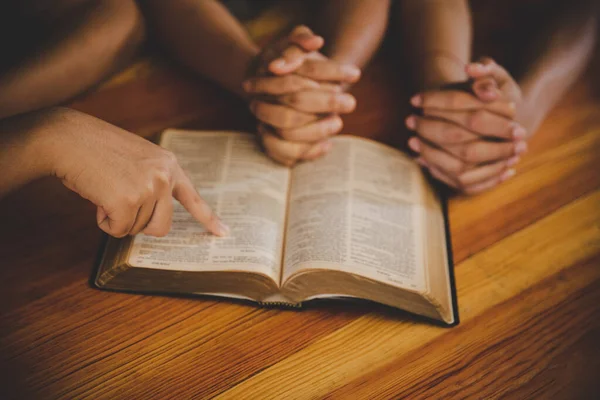 Hıristiyan ailesi evde Tanrı 'ya tapıyor, kutsal kitap ahşap masa üzerinde inanç, maneviyat, ibadet ve din kavramı..