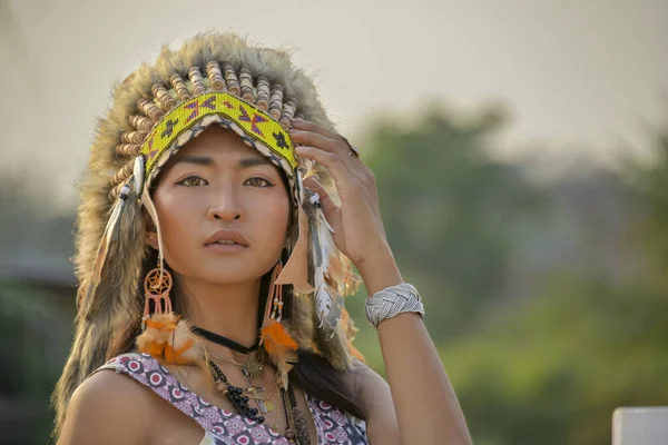 Savaş şapkalı kızılderili kadın Sunset 'te güzellik portresi. Amerikan yerlisi hippi kız bohem tarzında, Amerikan yerlisi tüyü başlıklı. Kızılderili başlıklı Boho kızı..