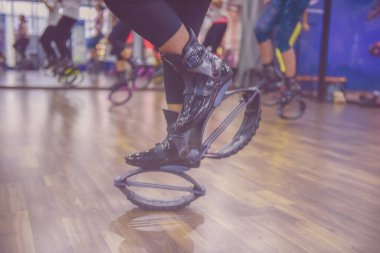 Tanımlanamayan bir grup kadının cam fitness stüdyosunda kangoo ayakkabılarla egzersiz yapmasının bulanıklığı. Bizim için en iyi arka plan. Çapraz işleme ve süreç gibi yeni bir renk eğilimi.
