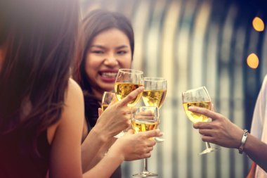 Parti başlasın. Şampanya kadehleriyle kadeh kaldıran mutlu insanlar. Çok ırklı arkadaşlar birbirlerini yeni yılla kutluyorlar. Kutlama tatili konsepti, tatil geçmişi. seçici odak.