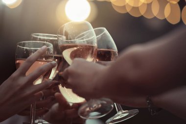 Parti başlasın. Şampanya kadehleriyle kadeh kaldıran mutlu insanlar. Çok ırklı arkadaşlar birbirlerini yeni yılla kutluyorlar. Kutlama tatili konsepti, tatil geçmişi. seçici odak.
