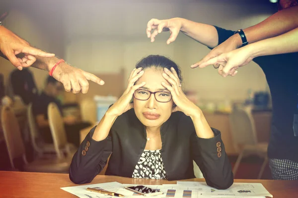 After Discussing the Coworkers pointer finger to a Serious headache Young business woman analyzing graph and chart document on office desk.Dramatic moment.Split tone instagram like