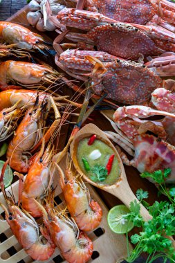 Tayland yaz tatilinde kapanış Tayland deniz ürünleri tabağı. Kepekli yengeç ve karides. Baharatlı yeşil soslu Tayland deniz ürünleriyle servis ediliyor. Lezzetli Okyanus gurmesi yemek geçmişi.