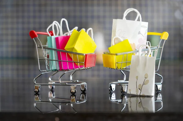 Küçük oyuncak oyuncak bebek, alışveriş çantasıyla dolu el arabası. Alışverişe düşkünlüğü mü yoksa alışverişe düşkünlüğü mü.