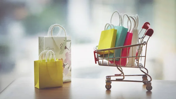 Küçük oyuncak oyuncak bebek, alışveriş çantasıyla dolu el arabası. Alışverişe düşkünlüğü mü yoksa alışverişe düşkünlüğü mü.