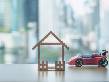 Mini ahşap ev ve oyuncak araba. İpotek ve gayrimenkul yatırımı veya Sigorta Finans ve Yatırım konsepti.