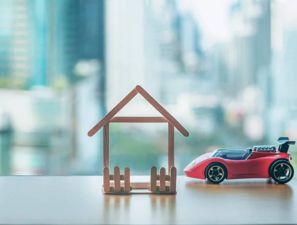 Mini ahşap ev ve oyuncak araba. İpotek ve gayrimenkul yatırımı veya Sigorta Finans ve Yatırım konsepti.