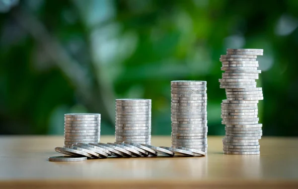 Bozuk para yığını bozuluyor. Mini ahşap ev ve bozuk para yığını düşüyor. İpotek ve gayrimenkul yatırımı veya Sigorta Finans ve Yatırım konsepti.