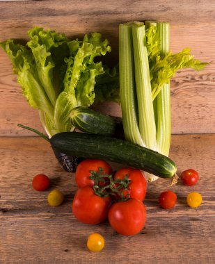 Kereviz, marul, salatalık, domates, ahşap arka planda kiraz domatesleri.