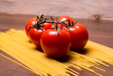 Spagetti üzerine domates, siyah arka planda makarna.