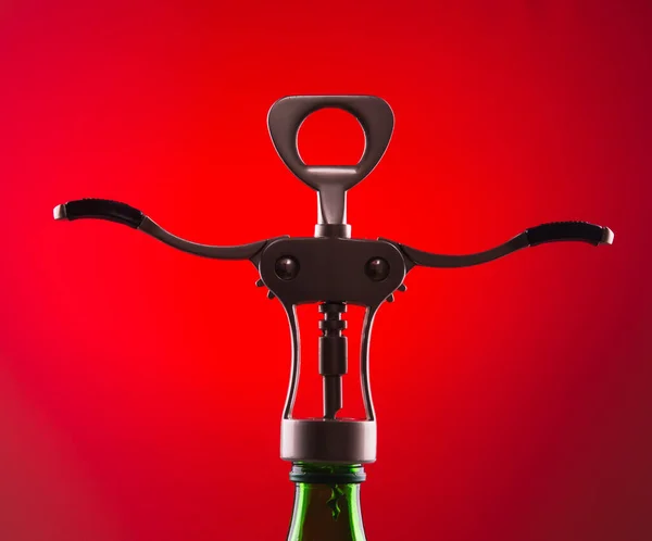Şişenin Boynundaki Kırmızı Arka Planda Şarap Şişelerini Açmak Için Tirbuşon — Stok fotoğraf