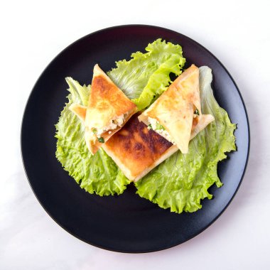  Süzme peynirli, otlu, domatesli, siyah beyaz tabaklı Pita üçgenleri.