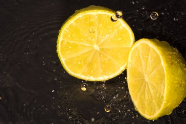  limon, lavman, dilimler, siyah arkaplanda su damlaları
