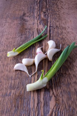 Yeşil soğan, ahşap arka planda sarımsak.
