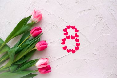 Gri taşlı arka planda sekiz şekilli güzel bahar laleleri ve kalpler. Sevgililer Günü kavramı, Kadınlar Günü 8 Mart, Anneler Günü. Metin için boşluk, düz uzanma.