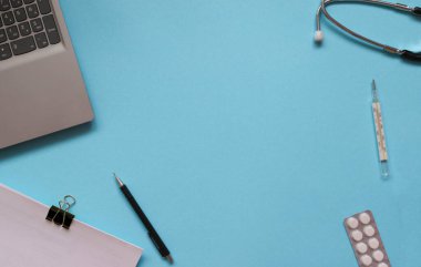 Mavi arka planda steteskop, tıbbi belgeler, termometre, şırınga ve haplarla tıbbi ekipmanların yaratıcı düzleşmesi. Sağlık hizmeti konsepti, kopya alanı olan üst görünüm