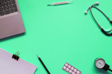 Steteskop, tıbbi belgeler, termometre, şırınga ve haplarla yeşil zemin üzerinde tıbbi ekipmanların yaratıcı düzleştirilmiş bileşimi. Sağlık hizmeti konsepti, kopya alanı olan üst görünüm