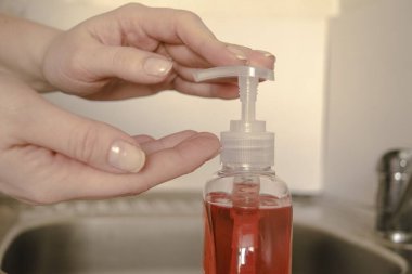 El dezenfektanı jel pompası kullanan beyaz kadın elleri, hijyen sağlığı konsepti.