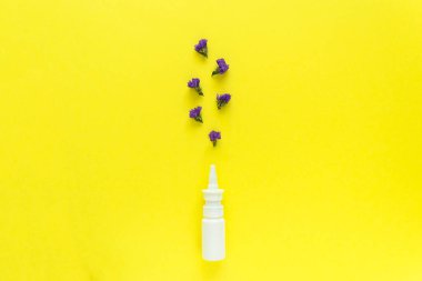 Mevsimlik bahar alerjisi çiçek konsepti. Sarı arka planda mor çiçekli beyaz sprey kutusu. Yaratıcı düz konum, kopyalama alanı, asgari biçim