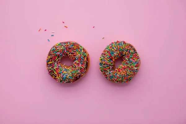 Dos rosquillas de chocolate sobre fondo rosa . —  Fotos de Stock