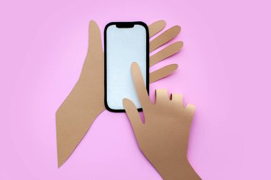 Kağıt ustası el ele tutuşur. Parmak ekrana dokunur. Pembe arkaplan. 