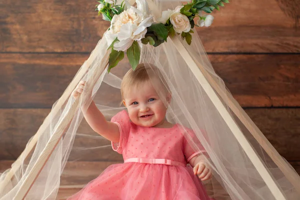 Cute little baby in pink dress. Decorative tent wih flower. — Stock Photo, Image