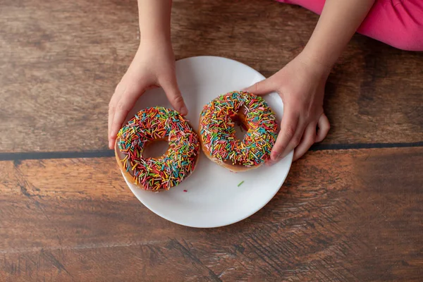 Donuts de chocolate en las manos de las niñas . —  Fotos de Stock