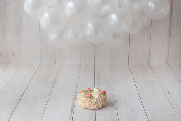 Balloon garland on wooden background. Smash cake decoration.