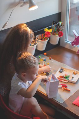 Masada oturan genç bir çocuk.